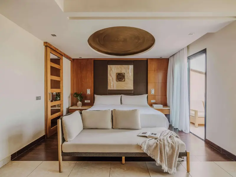Une chambre lumineuse avec un grand lit et un espace détente.