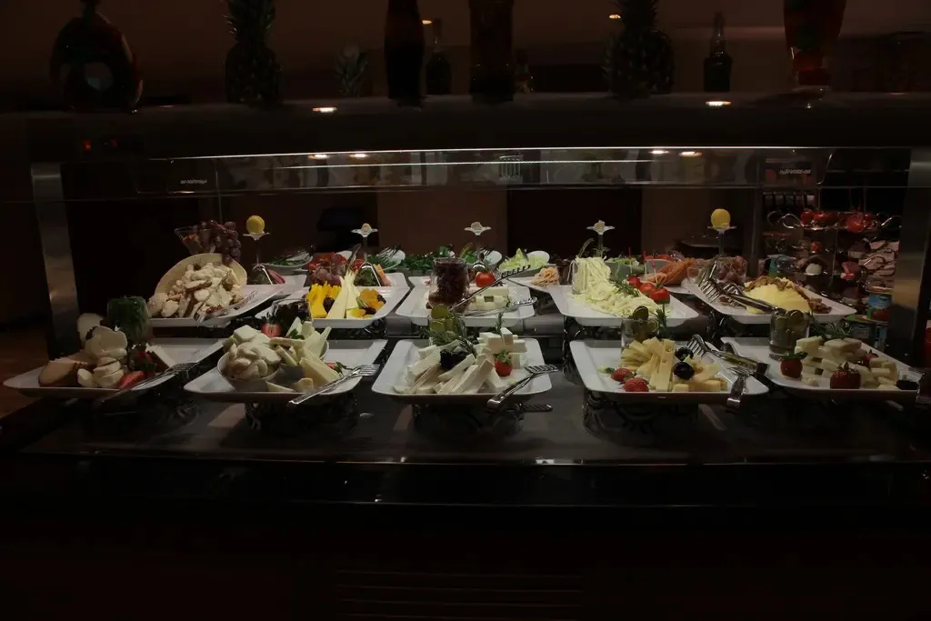 Présentation de divers plats froids et de salades sur un buffet.