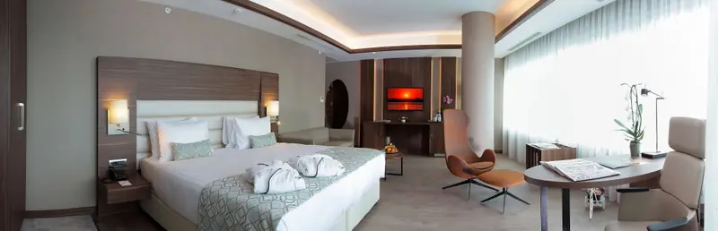 Une chambre lumineuse avec un grand lit et un espace détente.