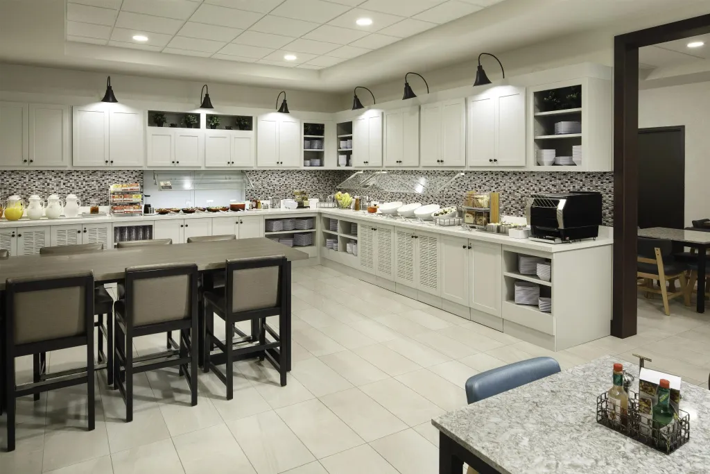 Une salle lumineuse présente un long comptoir de buffet avec des plats et des boissons.