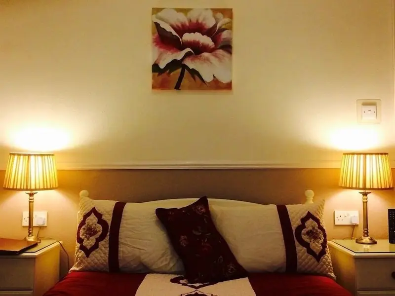 Un lit double avec des oreillers et des lampes de chevet.