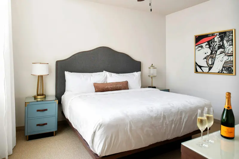 Une chambre lumineuse avec un grand lit recouvert d'une courtepointe blanche.