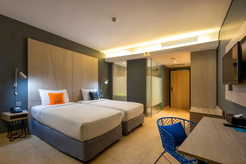 Une chambre moderne avec deux lits simples et un bureau.