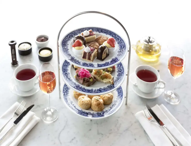Une présentation à trois niveaux de pâtisseries et de viennoiseries est mise en scène sur une table.