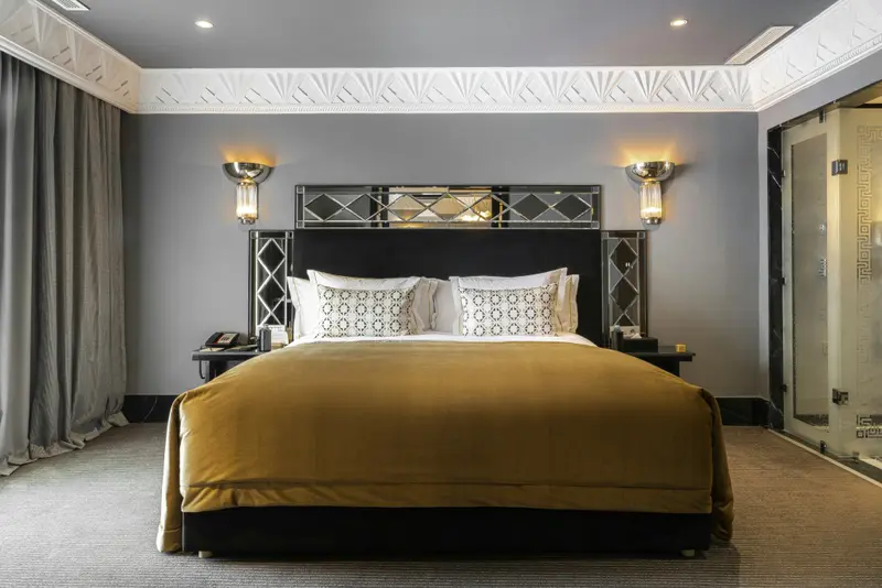 Une chambre d'hôtel avec un grand lit recouvert d'une courtepointe jaune.