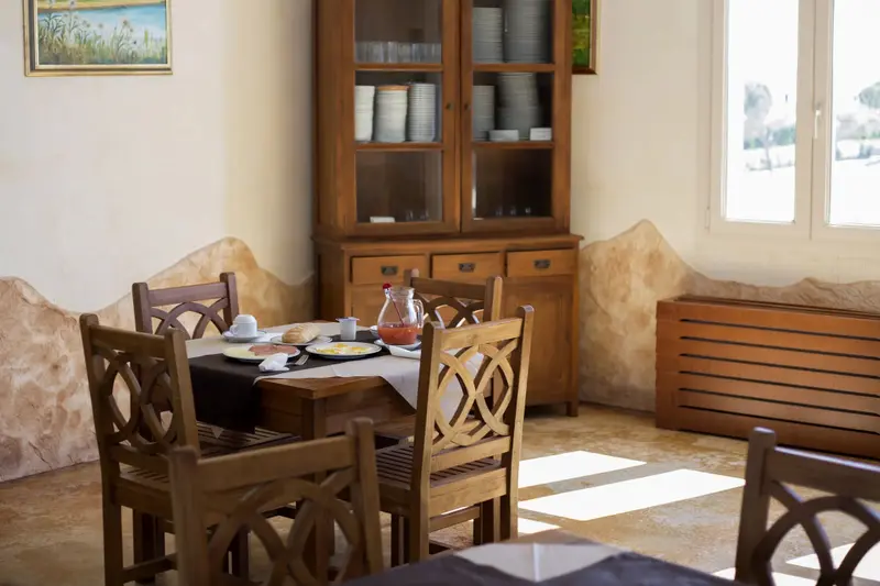 Une table est dressée pour le petit-déjeuner dans une salle lumineuse.