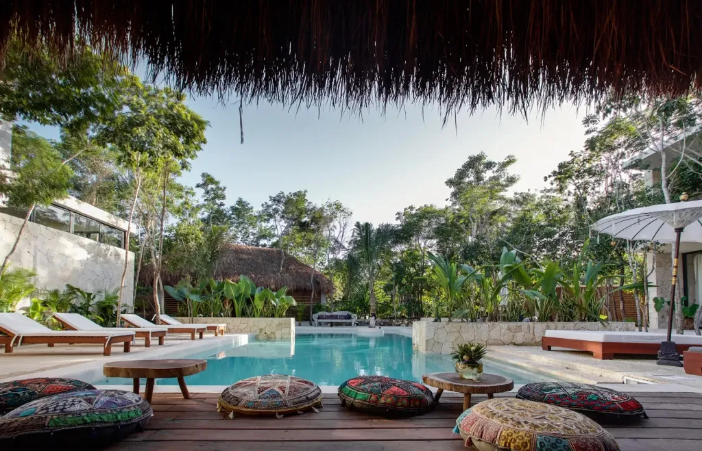 Espace de détente avec piscine et végétation luxuriante.