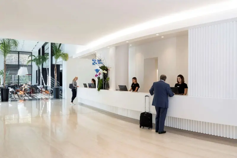 Un comptoir d'accueil lumineux avec du personnel et un client.