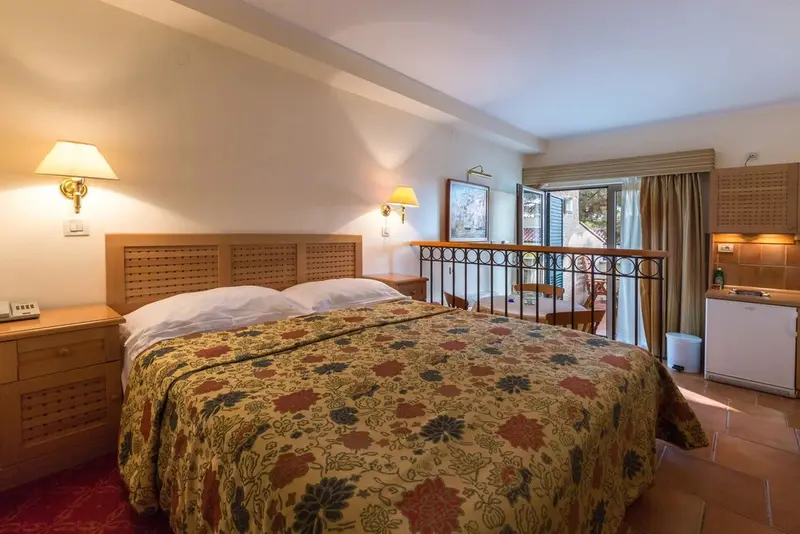Une chambre lumineuse avec un grand lit et un balcon.