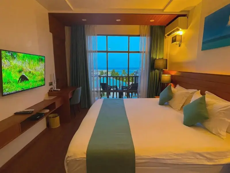 Une chambre lumineuse avec un grand lit et une vue sur la mer.