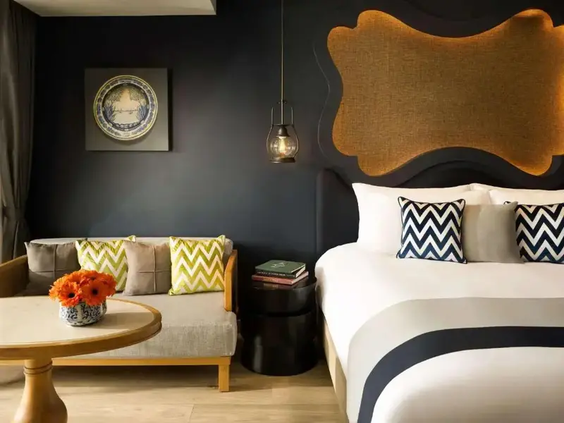 Une chambre à coucher avec un canapé et un lit décorés de coussins.