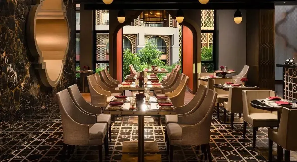 Une salle de restaurant élégante avec des tables dressées et un décor raffiné.