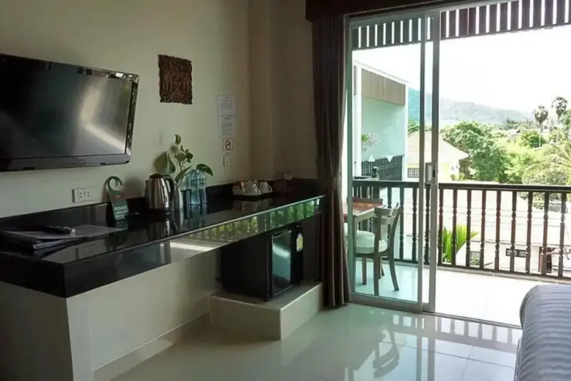 Une kitchenette moderne s'ouvre sur une terrasse avec vue sur la végétation.