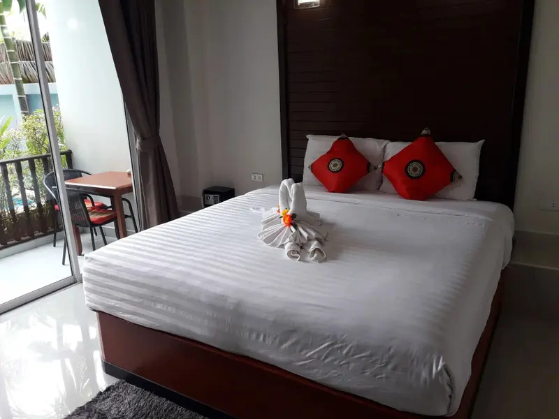 Une chambre lumineuse avec un grand lit et un balcon.
