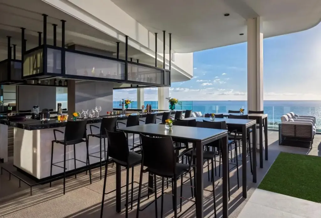 Un espace bar et salle à manger moderne offre une vue dégagée sur la mer.