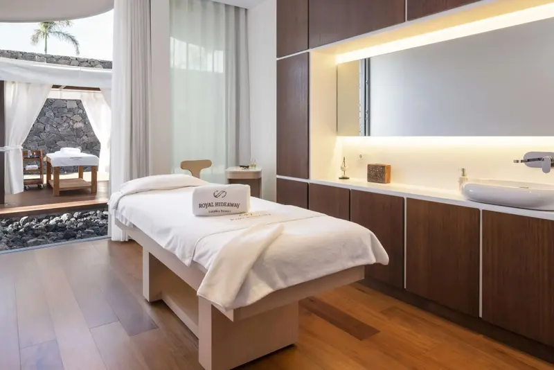 Une table de massage est préparée dans une pièce lumineuse et moderne.