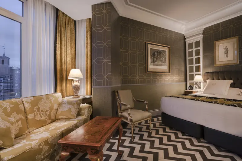 Une chambre lumineuse avec un canapé, une table basse et un lit.