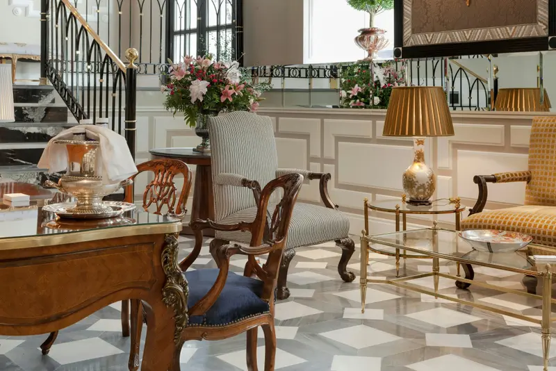 Un espace de réception élégant avec des fauteuils et des tables décoratives.