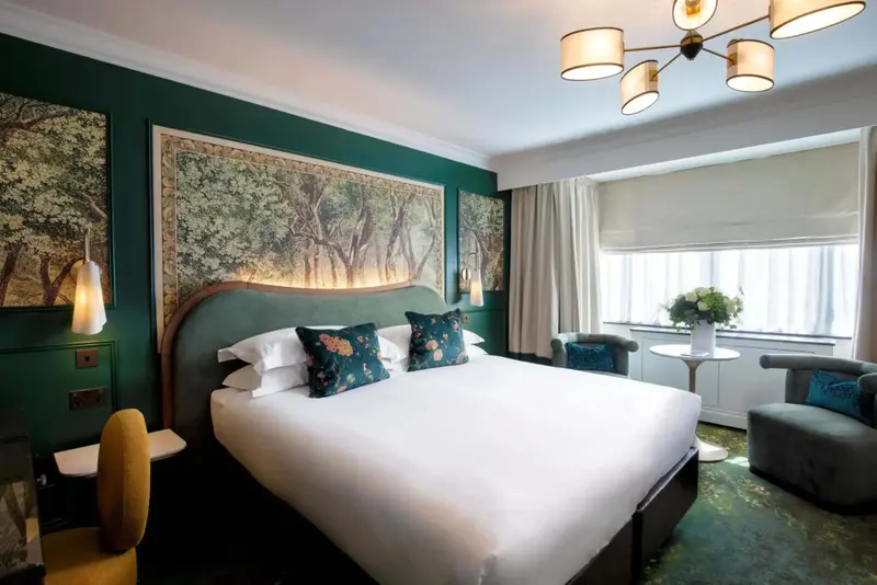 Une chambre lumineuse avec un grand lit et un décor floral.