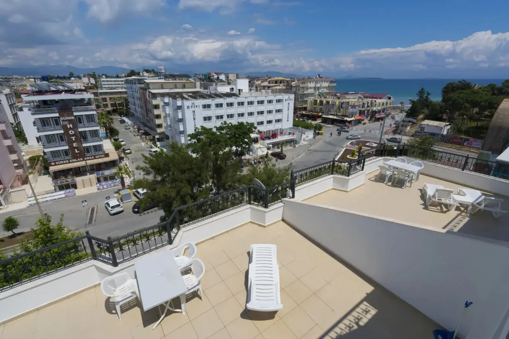 Terrasse avec mobilier blanc surplombant une ville côtière.