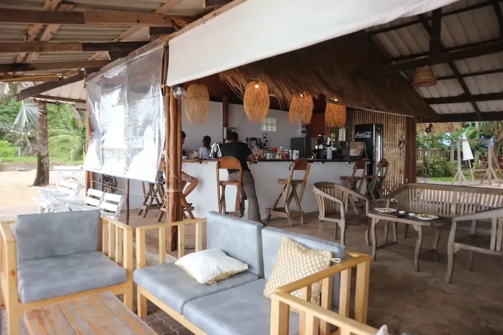 Un espace de détente en bord de mer avec un bar et des canapés.