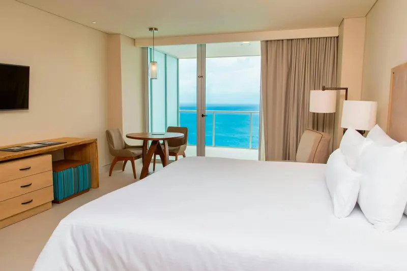 Une chambre lumineuse avec un grand lit et une vue sur la mer.