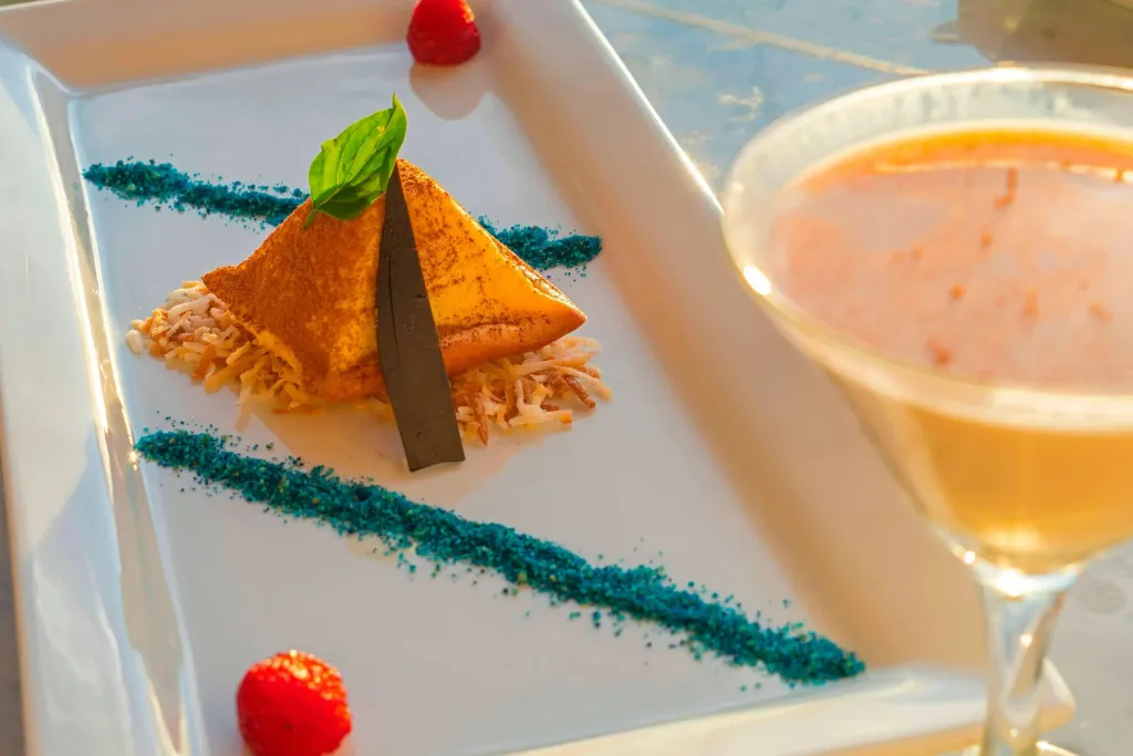 Assiette de dessert et verre de boisson colorés sur une table.