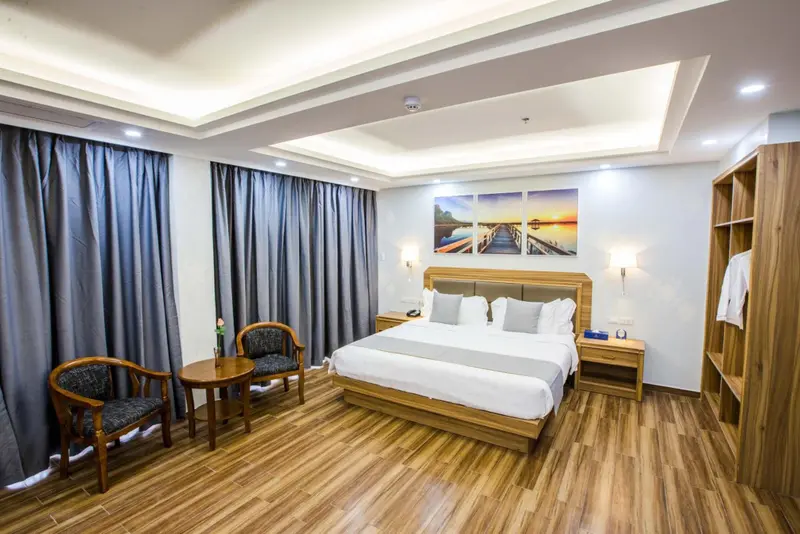 Une chambre lumineuse avec un grand lit et un coin salon.