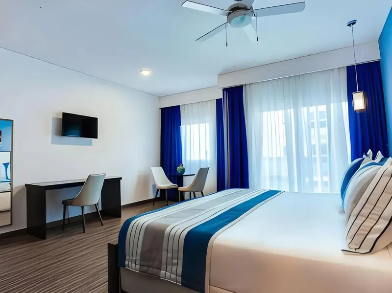 Une chambre lumineuse avec un grand lit et un espace bureau.