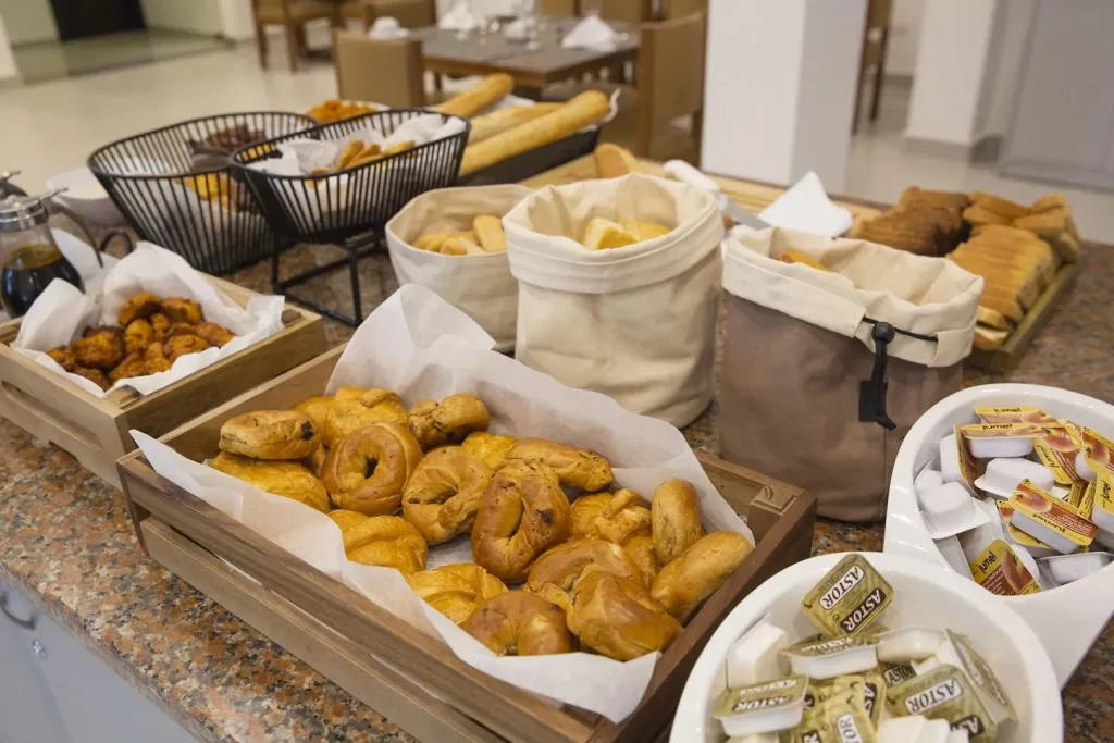 Un buffet propose une variété de viennoiseries et de pains.