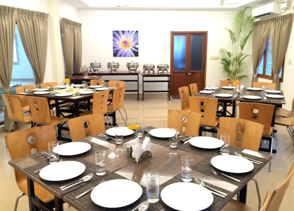 Une salle lumineuse avec des tables dressées pour un repas.