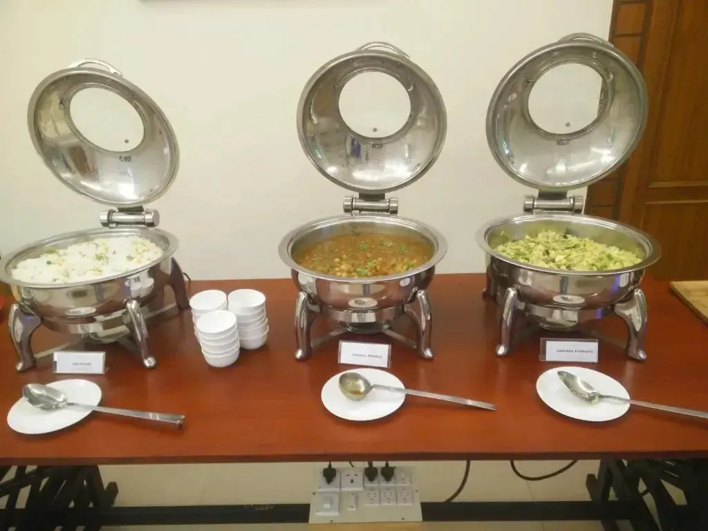 Des plats chauds sont présentés sur un buffet.