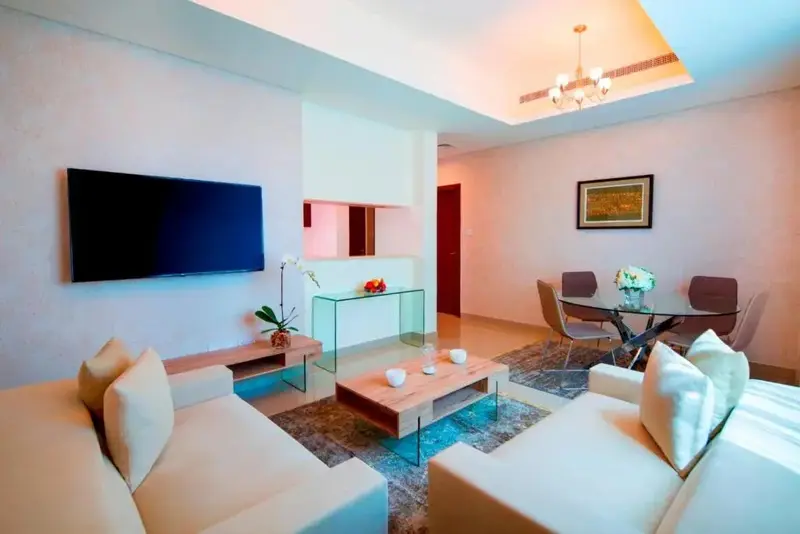 Un espace de vie lumineux avec canapés, table basse et salle à manger.