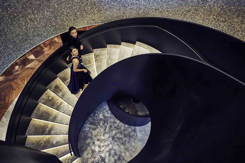 Un couple descend un escalier en colimaçon moderne et élégant.