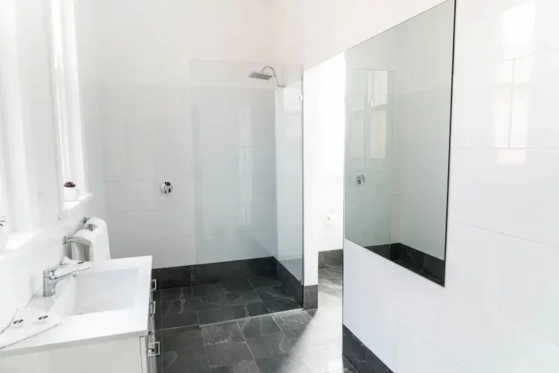 Une salle de bain moderne avec douche à l'italienne et grand miroir.