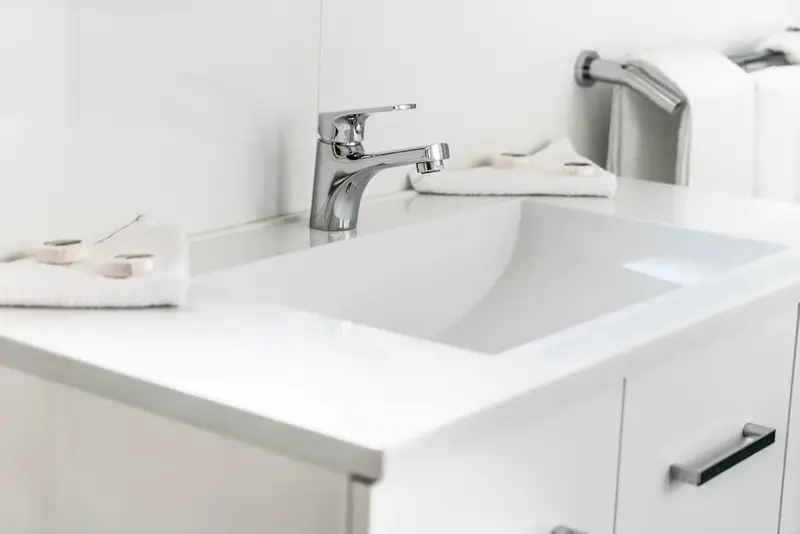 Un lavabo blanc avec des accessoires de salle de bain.