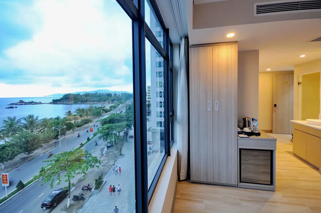 Vue sur la mer depuis une chambre d'hôtel lumineuse.