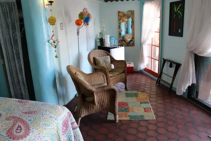 Espace de détente intérieur avec mobilier en rotin et décoration colorée.