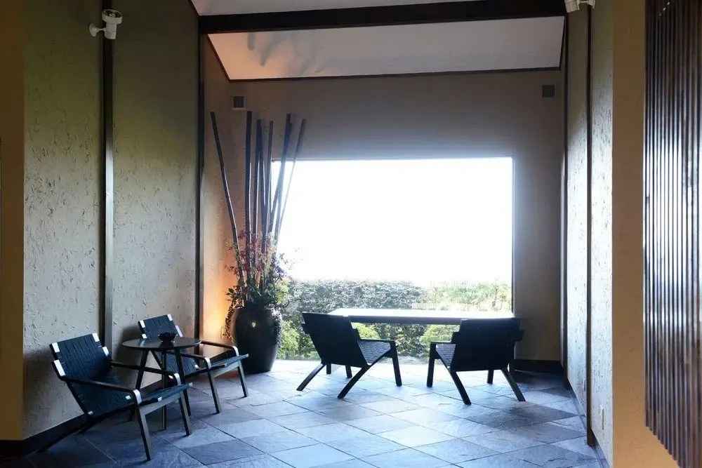 Espace de détente extérieur avec mobilier et vue sur la végétation.