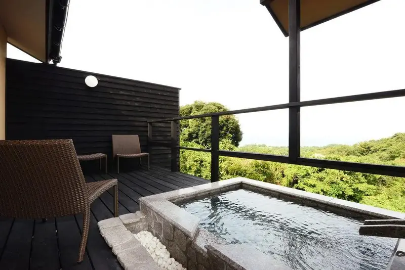 Terrasse avec jacuzzi et vue sur la végétation.