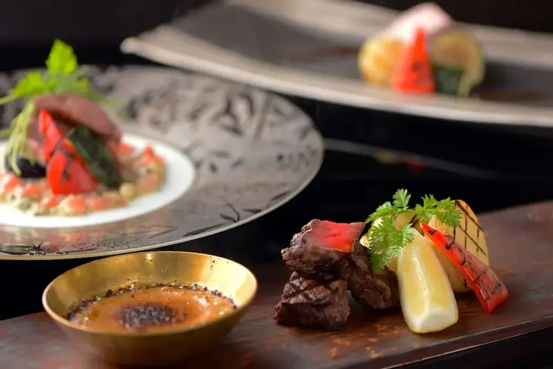 Présentation raffinée de plats gastronomiques sur des assiettes et un plateau en bois.
