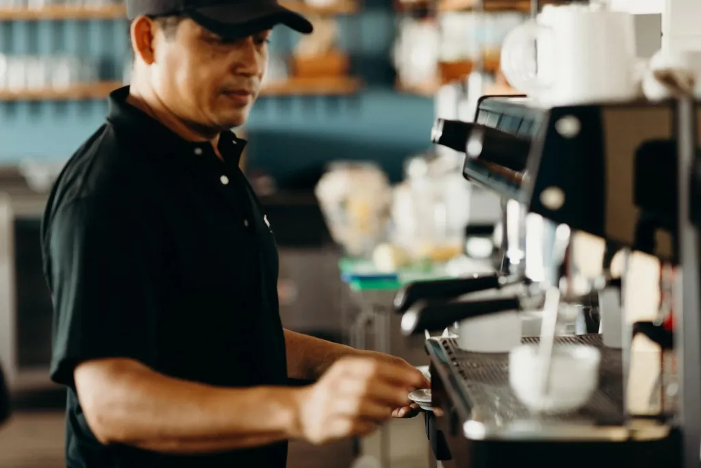 Un homme prépare une boisson derrière un comptoir.