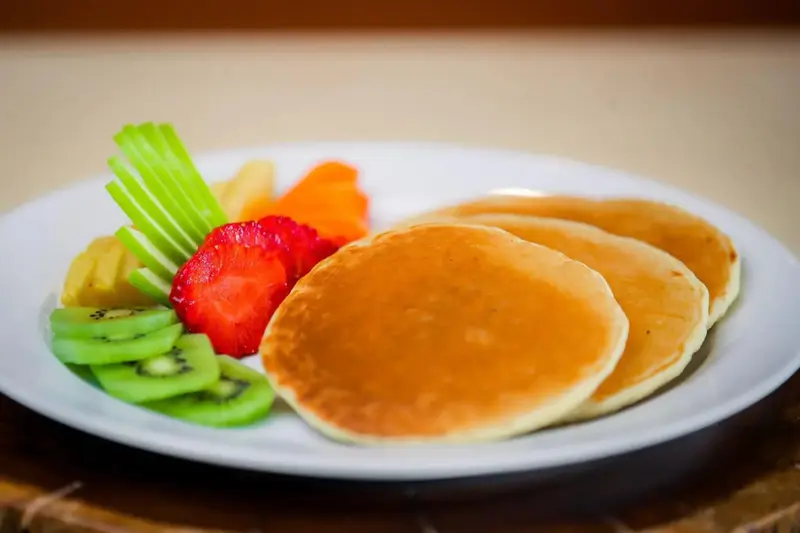Assiette de crêpes servies avec des fruits frais et des légumes.