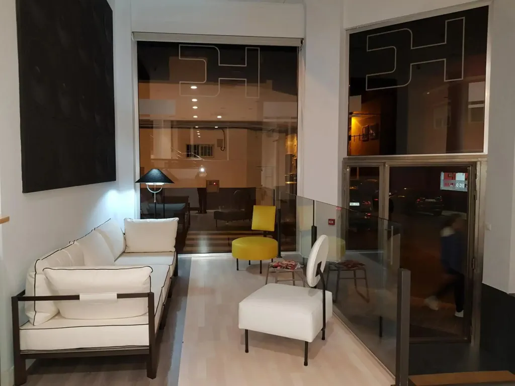 Espace de détente intérieur avec canapés et fauteuils.