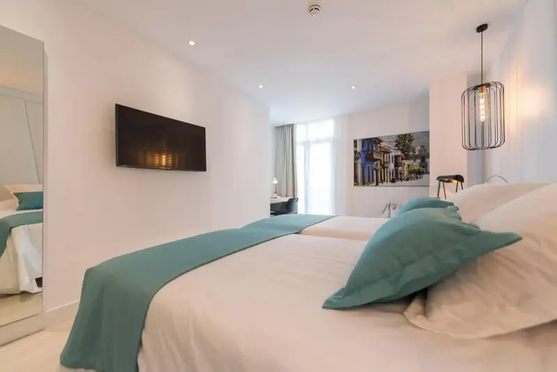 Une chambre lumineuse avec un grand lit et une décoration sobre.