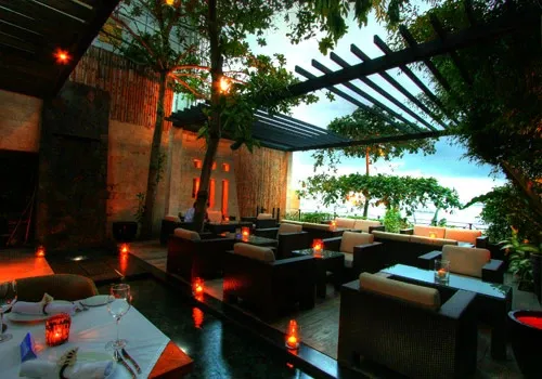 Terrasse aménagée avec des salons et des tables éclairées aux chandelles.