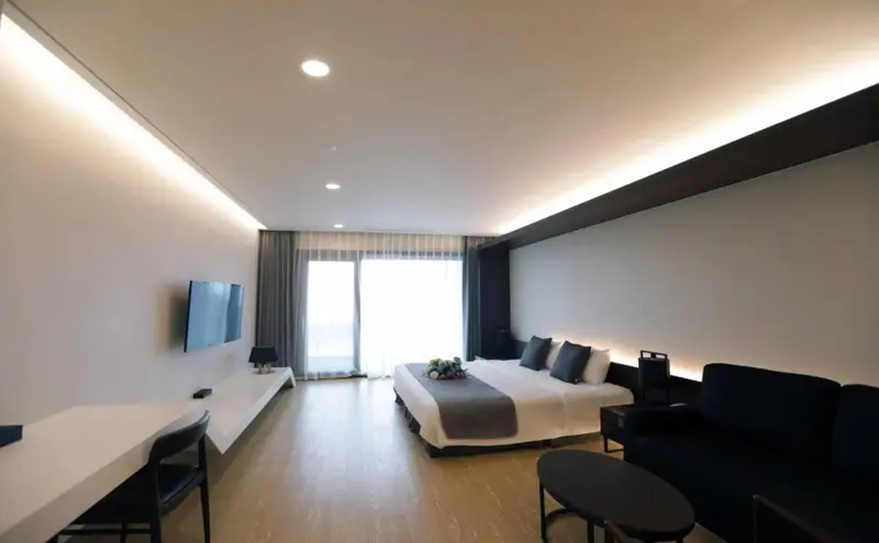 Une chambre lumineuse avec un grand lit et un espace salon.