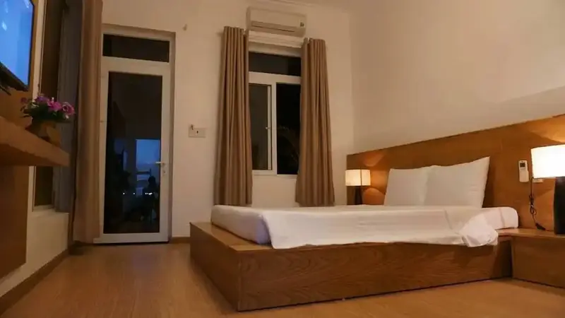 Une chambre lumineuse avec un grand lit et un accès à une terrasse.