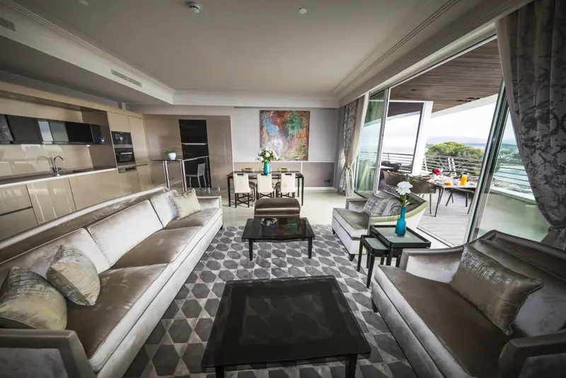 Espace de vie lumineux avec canapés, table basse et accès à une terrasse.