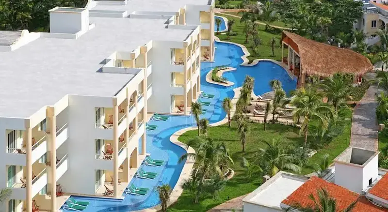 Vue aérienne d'un complexe hôtelier avec des piscines sinueuses et une végétation luxuriante.